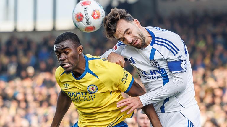 Salomon Nkoa (Eintracht Braunschweig) im Duell mit Kenan Karaman (FC Schalke 04) im Eintracht-Stadion.