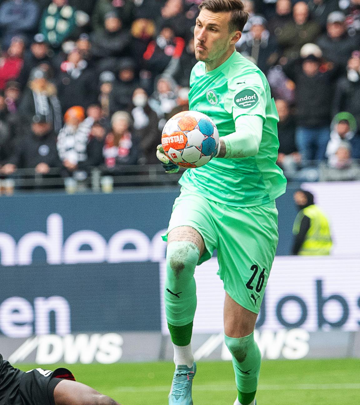 02.04.2022, Hessen, Frankfurt/Main: Fußball: Bundesliga, Eintracht Frankfurt - SpVgg Greuther Fürth, 28. Spieltag, Deutsche Bank Park. Fürths Torwart Andreas Linde (r) hält gegen Frankfurts Evan Ndicka (M) und Frankfurts Tuta.