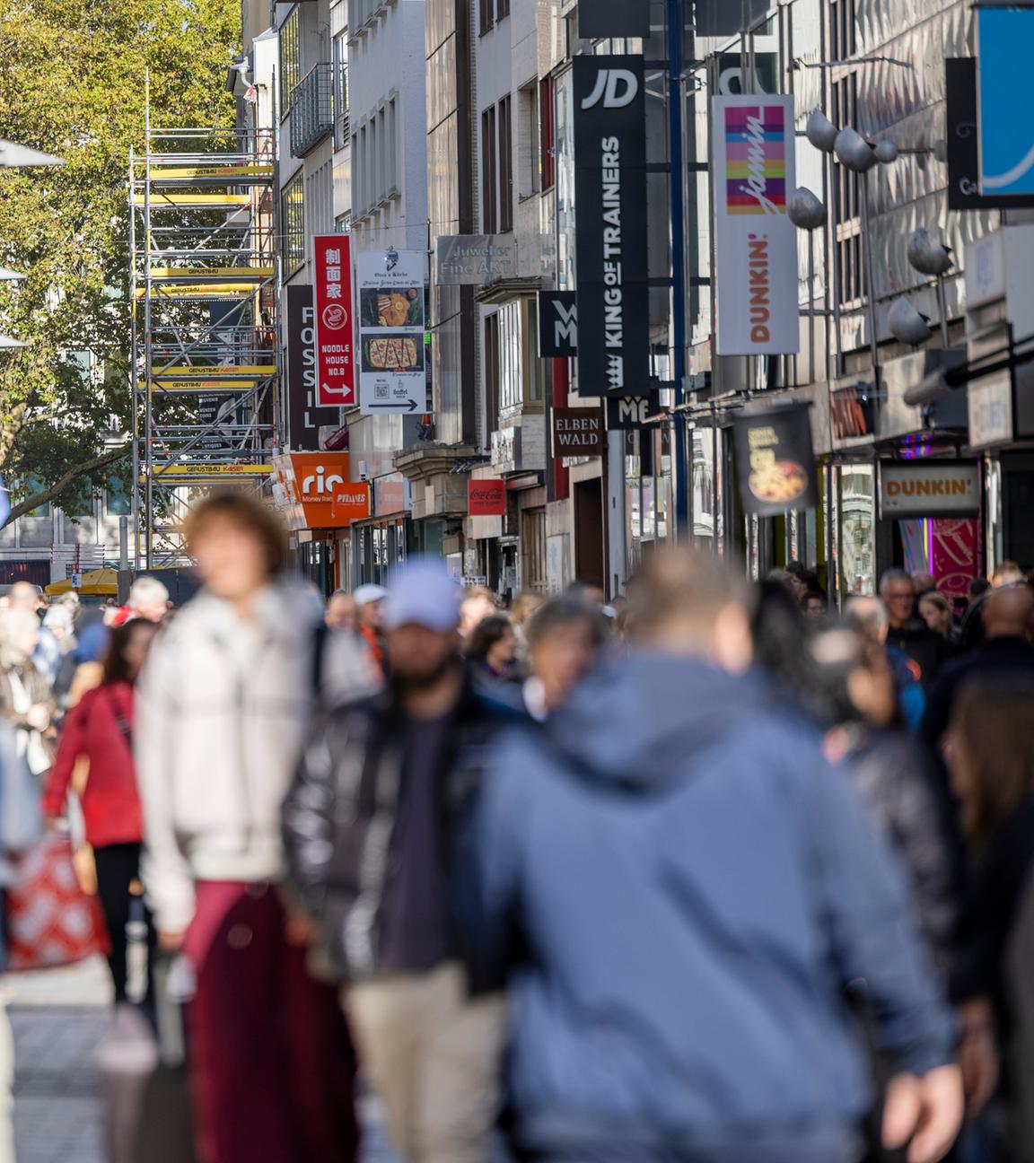 Passanten passieren diverse Geschäfte in der Kölner Fußgängerzone Hohe Straße am 23.10.2025. 