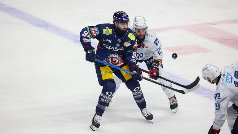 Liam Kirk von den Eisbären Berlin und Kris Bennett von Adler Mannheim kämpfen um den Puck.