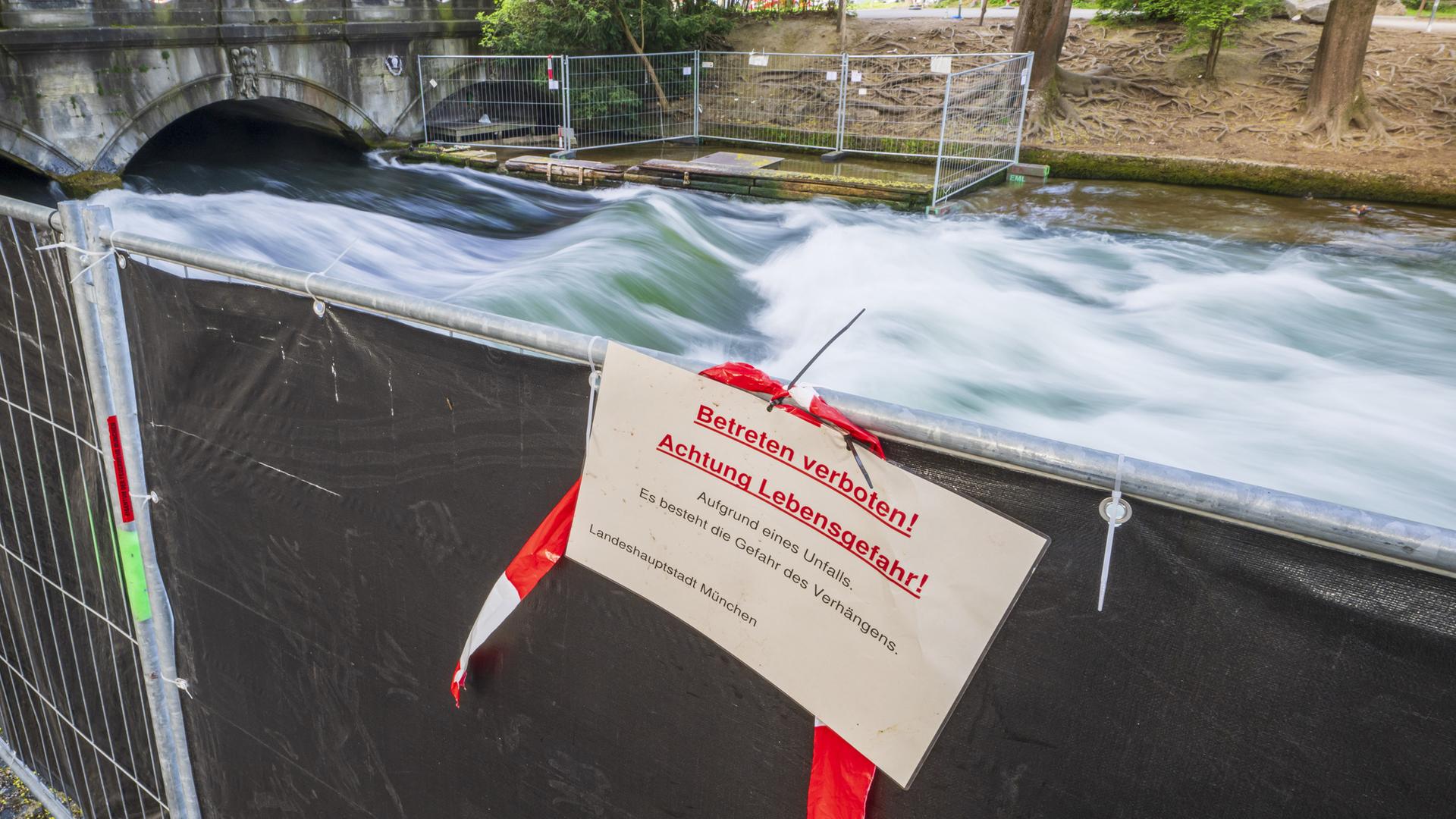 Ein Schild mit der Aufschrift "Betreten verboten! Achtung Lebensgefahr!" hängt an einer Absperrung vor der künstliche Welle am Eisbach.
