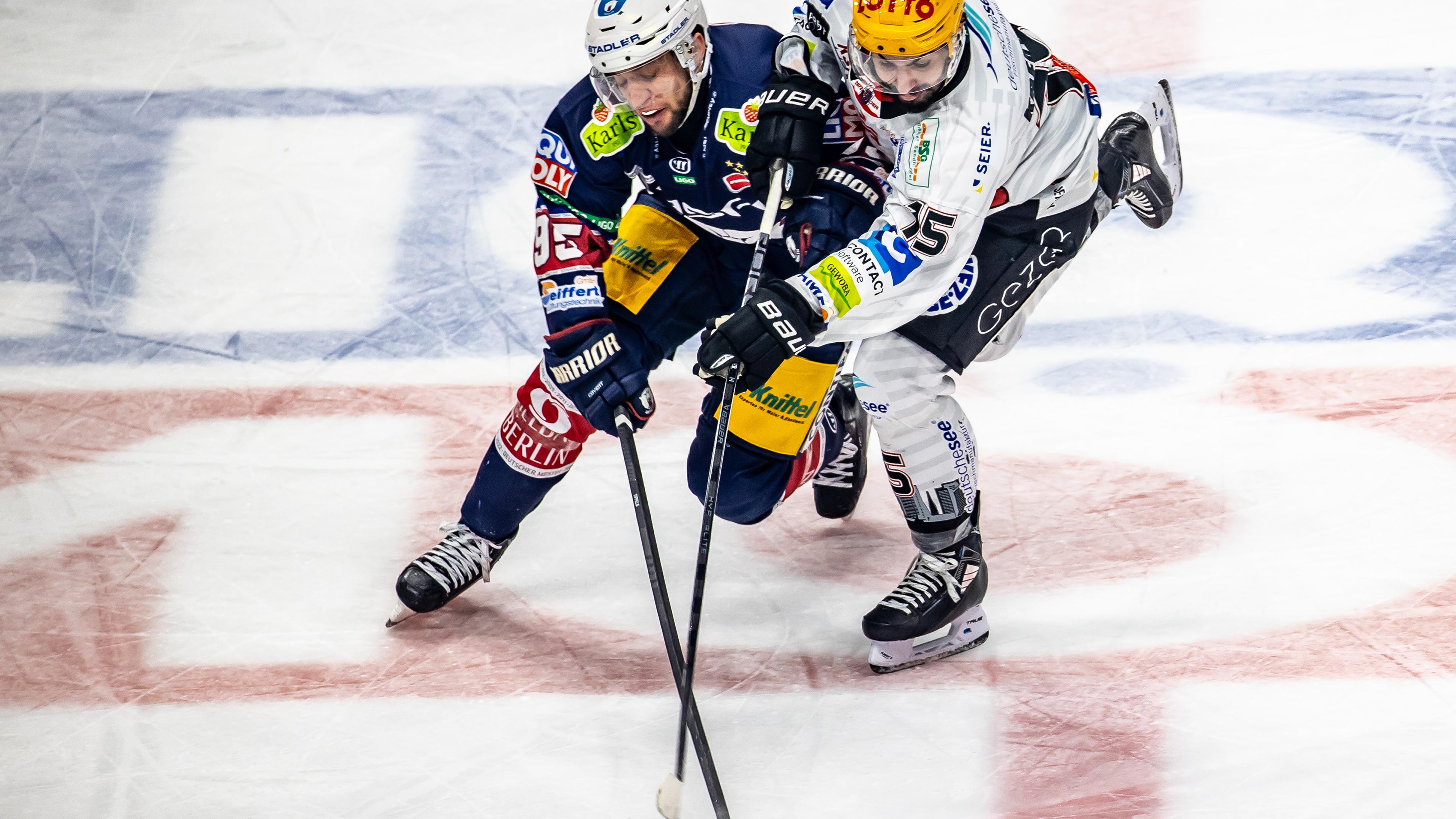 Berlin: Eishockey: DEL, Eisbären Berlin - Pinguins Bremerhaven: Berlins Frederik Tiffels (l) kämpft gegen Gregory Kreutzer von Pinguins Bremerhaven um den Puck.