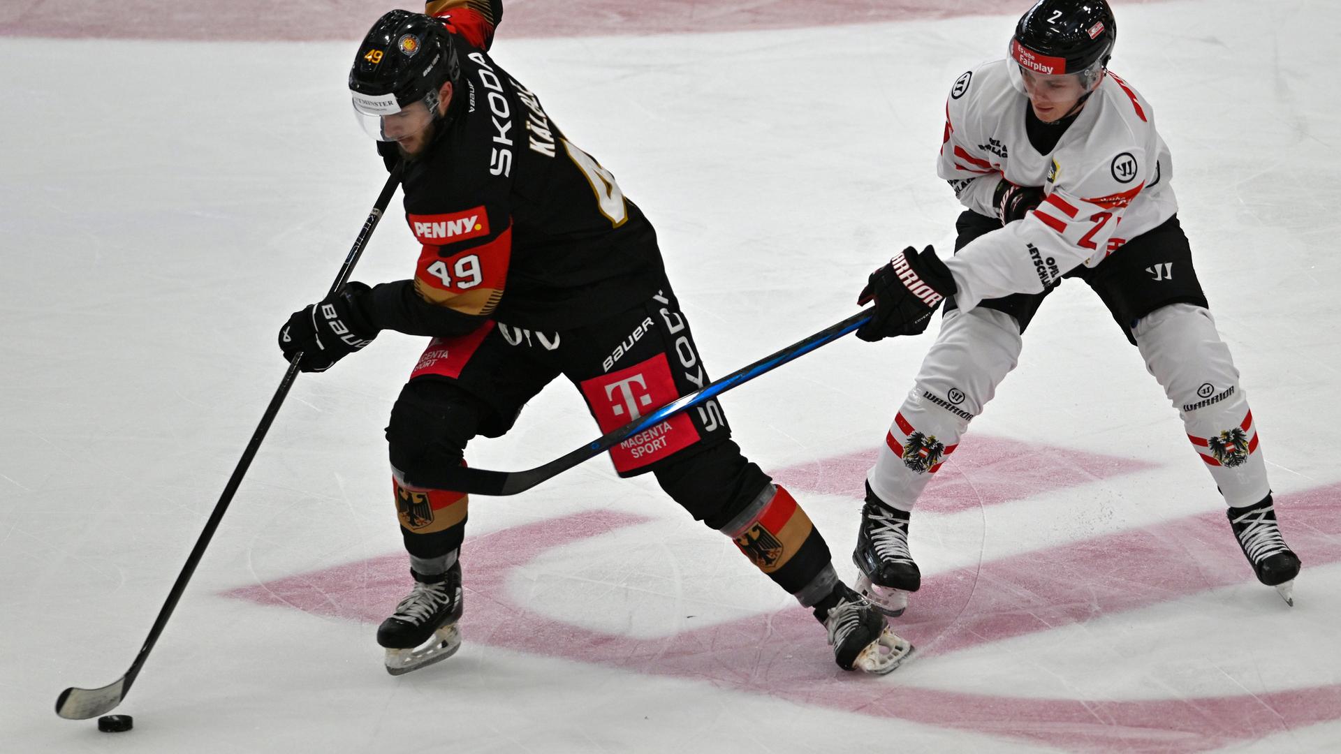 Deutschlands Lukas Kälble und Österreichs Luis Lindner kämpfen um den Puck beim Spiel am 26.04.2025.