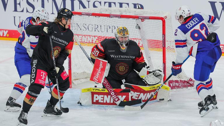 Deutschands Torwart Philipp Grubauer hält den Schuss von Logan Cooley aus den USA.