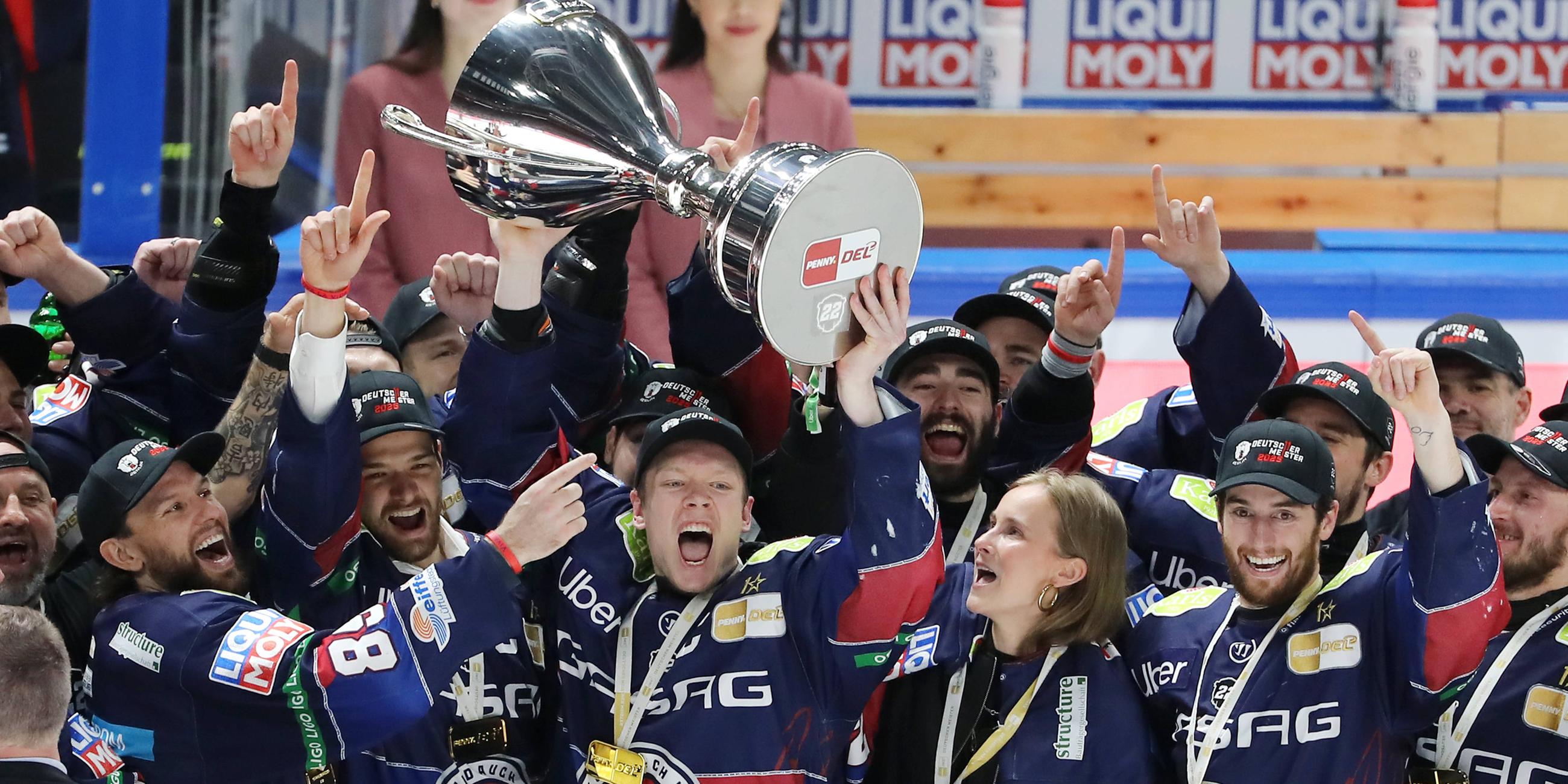 Die Spieler der Berliner Eisbären jubeln mit Pokal zum Sieg der deutschen Meisterschaft.
