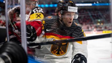 Der deutsche Eishockeynationalspieler Leon Hüttl versucht sich bei der Eishockey-WM im Gruppenspiel gegen seinen österreichischen Kontrahenten Paul Huber durchzusetzen