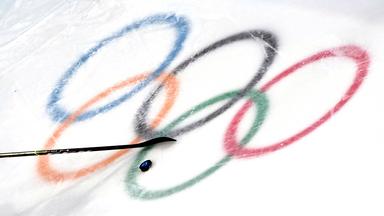 Die olympischen Ringe im Eis mit Puk und Schläger.