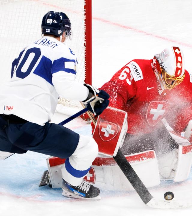 Saku Mäenalanen im Zweikampf um den Puck mit dem Schweizer Torhüter Leonardo Genoni bei der Eishockey-WM.