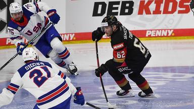 Der US-amerikanisch-deutsche Hockeyspieler Parker Tuomie setzt sich im Eishockey Testspiel gegen seine amerikanischen Konkurrenten Alex Steeves und Connor Clifton durch