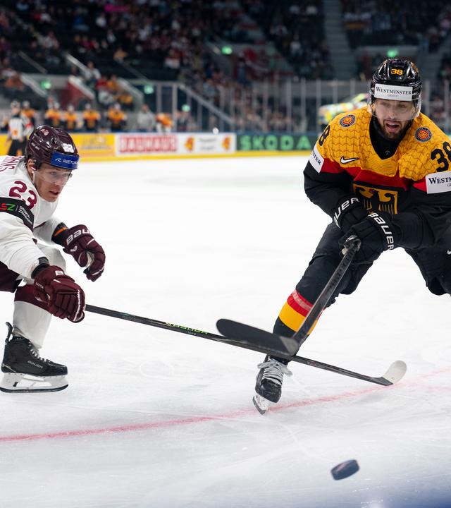 Lettlands Sandis Vilmanis (l) kämpft um den Puck gegen Deutschlands Fabio Wagner