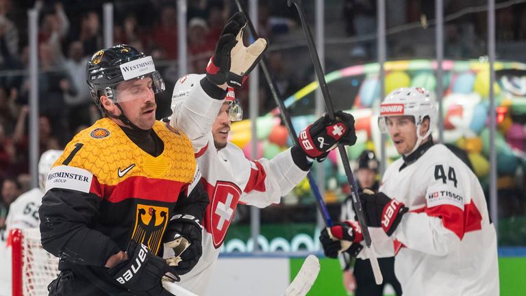 Eishockey: WM, Schweiz - Deutschland. Der Schweizer Sven Andrighetto (Mitte) feiert sein Tor zum 6:0 mit Teamkollege Pius Suter (rechts). Der Deutsche Maximilian Kastner (links) zeigt Niedergeschlagenheit.