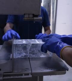 Eiswürfel werden mit einer Maschine in einem Kühlhaus gesägt.