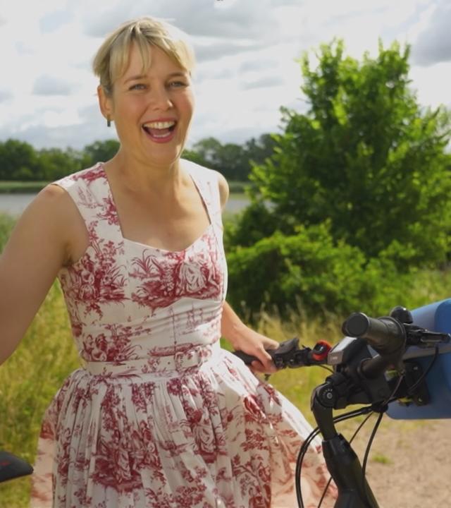 Marina Wenk sitzt lachend auf dem Fahrrad