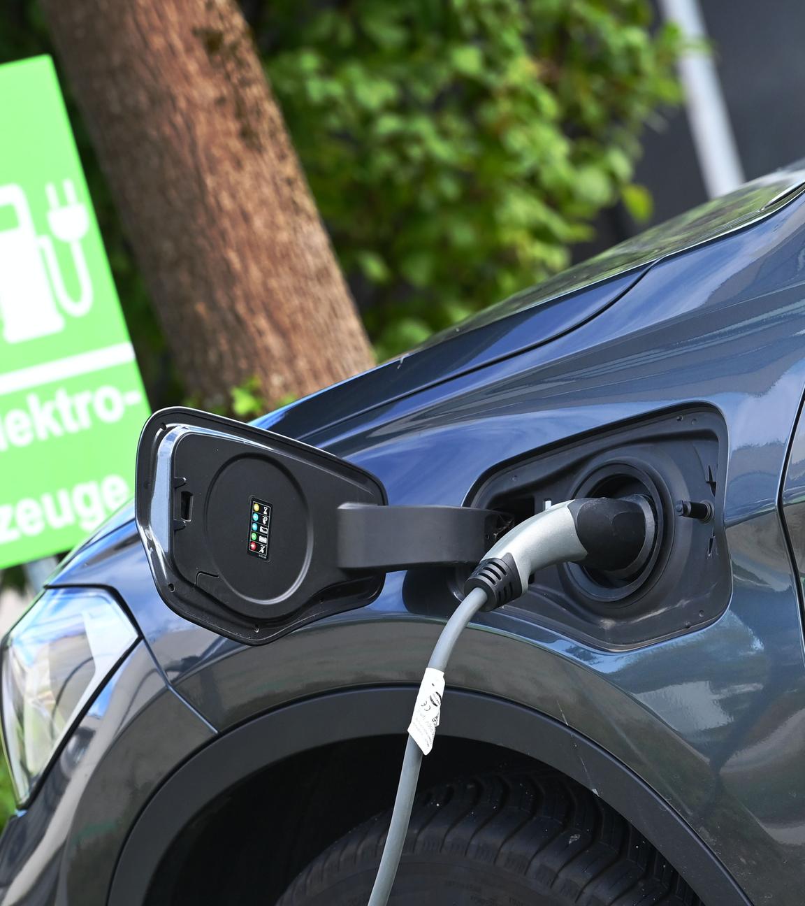 Ein Stecker hängt an einem Elektroauto während eines Ladevorgangs.
