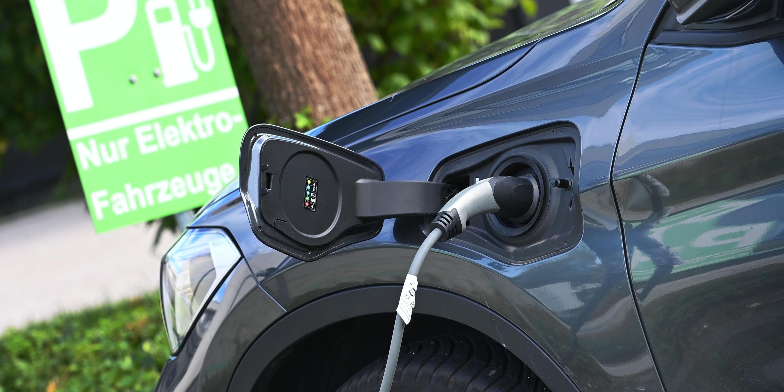 Ein Stecker hängt an einem Elektroauto während eines Ladevorgangs.