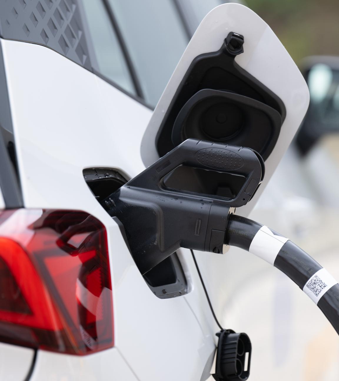 Ein Ladekabel steckt auf einem Ladepark der EnBW Energie Baden-Württemberg AG im Tankstutzen eines Elektroautos. 