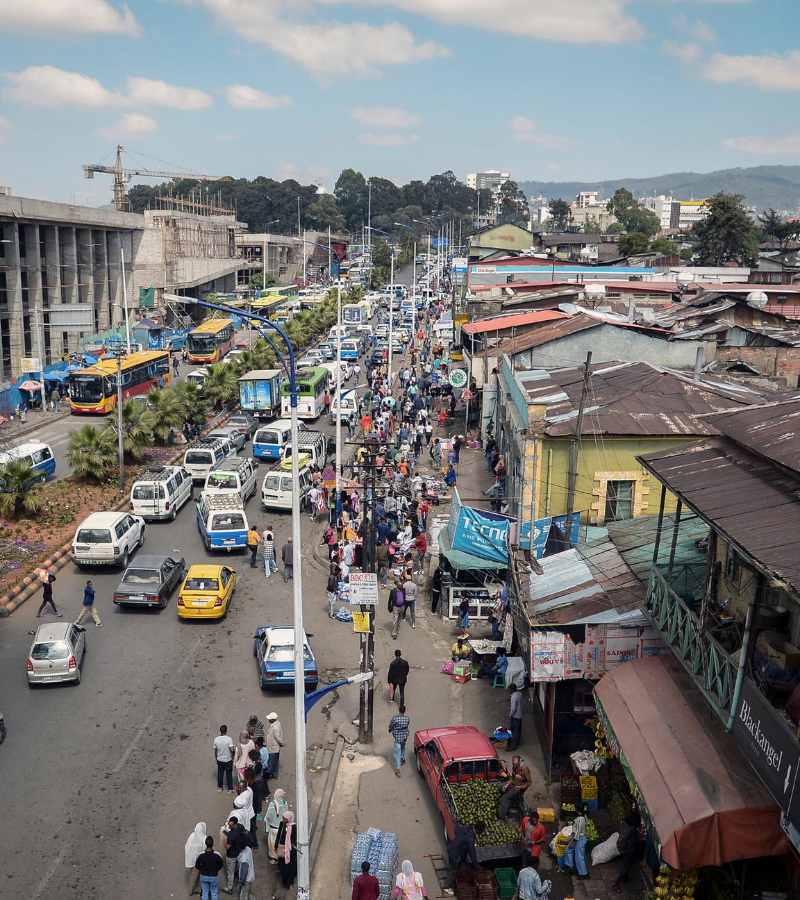 Verkehr und viele Fußgänger auf einer belebten Straße in Addis Abeba, Äthiopien.