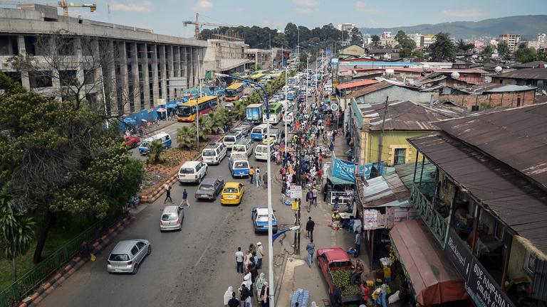 Verkehr und viele Fußgänger auf einer belebten Straße in Addis Abeba, Äthiopien.