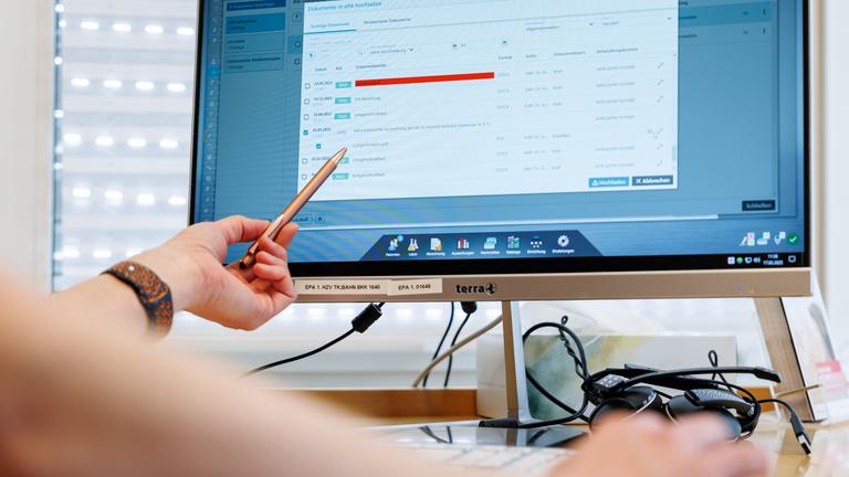 Ein Hausarzt lädt in seiner Praxis Dokumente in eine elektronische Patientenakte "ePA".