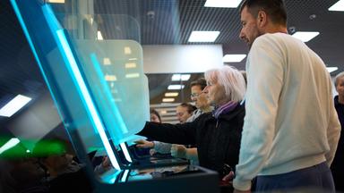 Ein Mitglied einer Wahlkommission (rechts) hilft einer Wählerin bei der Nutzung eines elektronischen Wahlsystems während der Parlamentswahlen in Moskau, Russland, am 19.09.2026. 