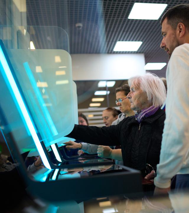 Ein Mitglied einer Wahlkommission (rechts) hilft einer Wählerin bei der Nutzung eines elektronischen Wahlsystems während der Parlamentswahlen in Moskau, Russland, am 19.09.2026. 
