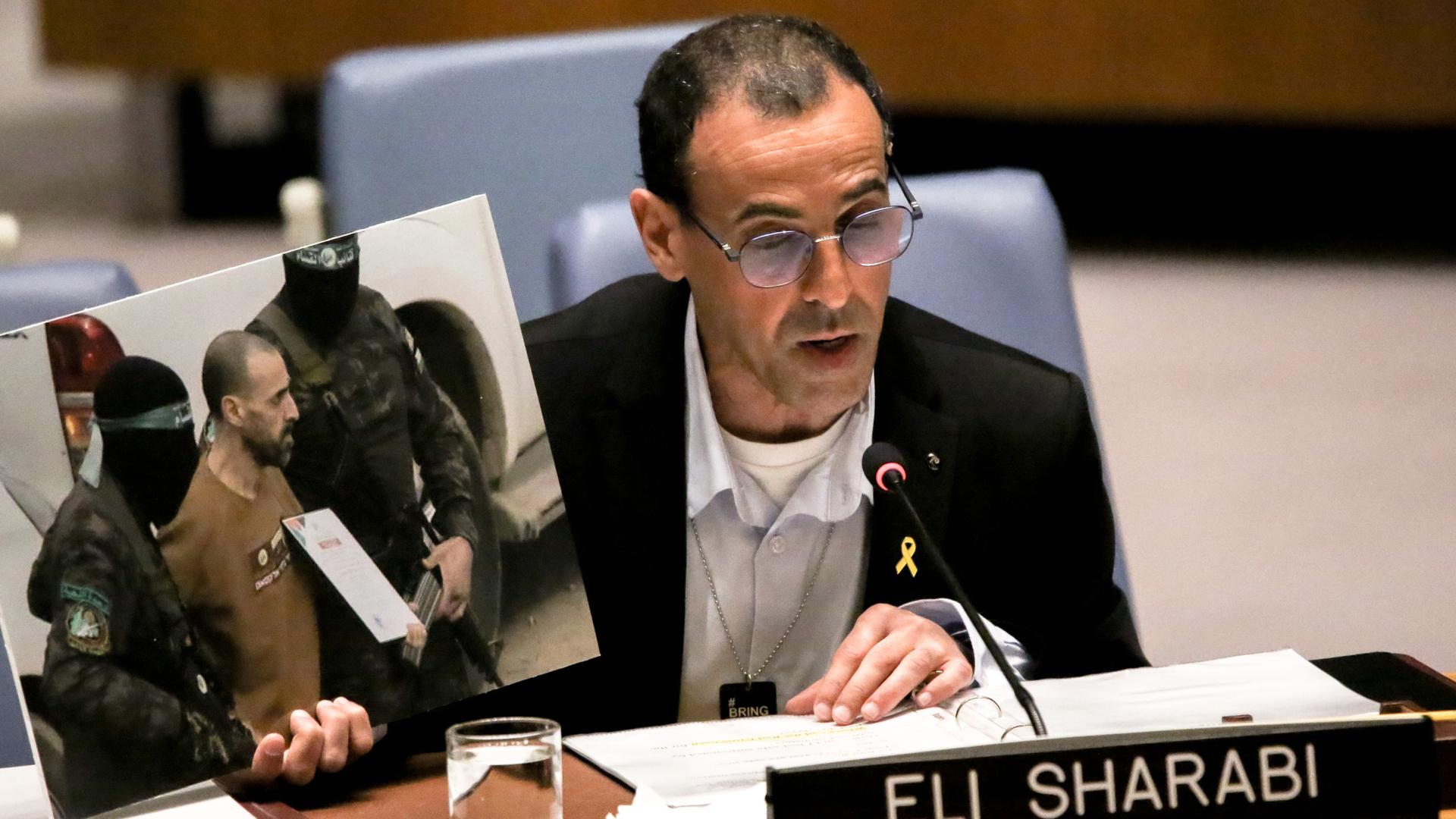 USA, New York: Eli Sharabi, der am 07. Oktober von Hamas-Truppen aus seinem Haus entführt wurde, hält ein Foto von seiner Freilassung durch die Hamas im Rahmen eines Geiselaustauschs hoch