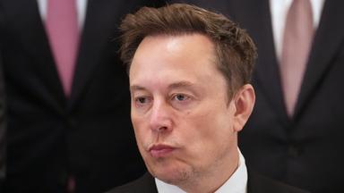 n: Elon Musk hört zu, während US-Präsident Trump im East Room des Weißen Hauses in Washington bei einem Treffen mit Führungskräften von KI-Unternehmen spricht.