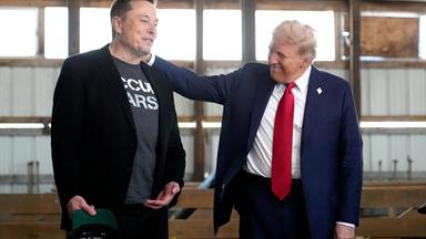 Donald Trump legt Elon Musk die Hand auf die Schulter.