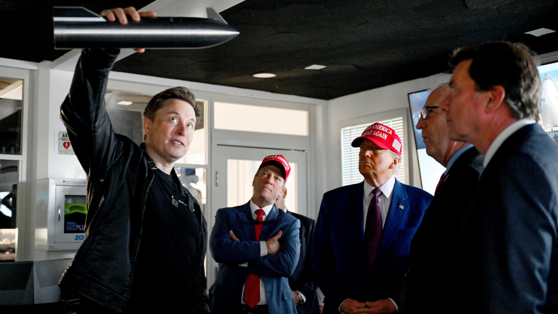 Der designierte US-Präsident Donald Trump (M) hört zu, als Elon Musk (l) die Abläufe vor dem Start des sechsten Testflugs der SpaceX Starship-Rakete in Brownsville, Texas, erklärt. 