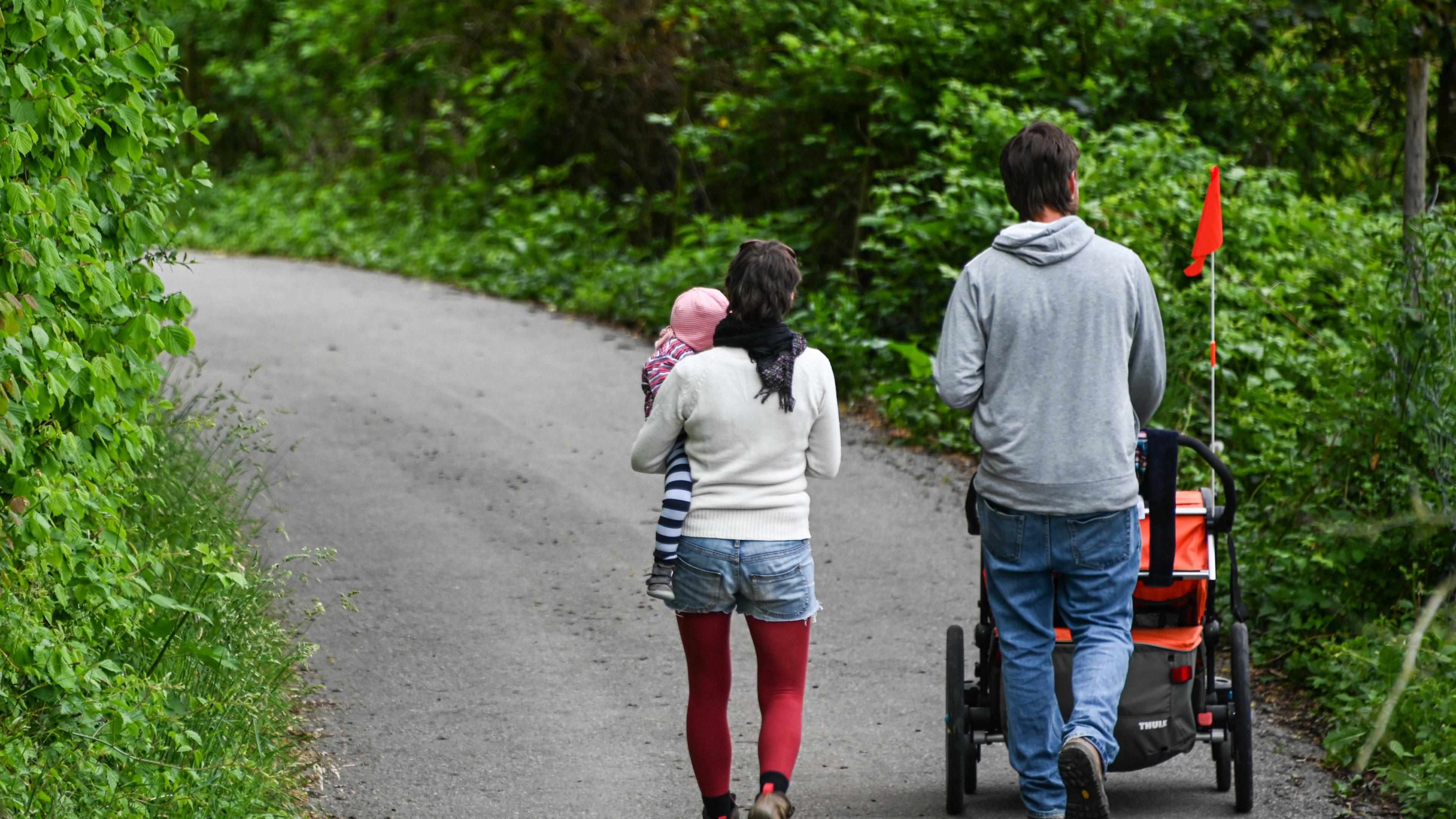 Das Bild zeigt eine Familie, die eine Straße entlang läuft