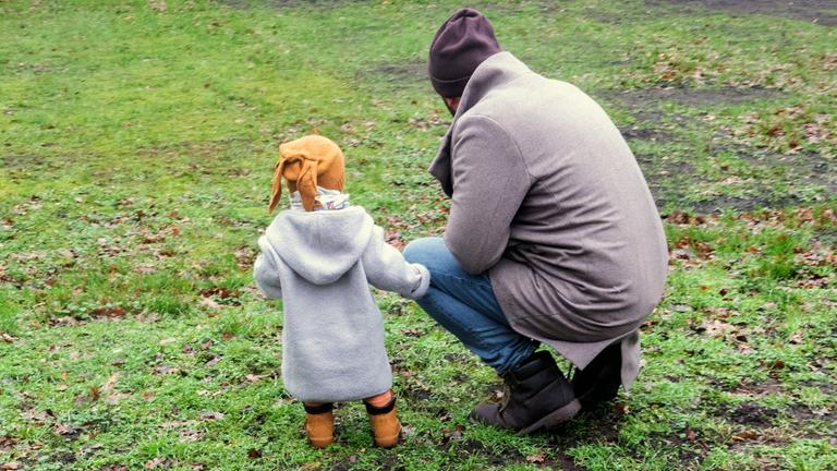Ein Vater spielt mit seinem Kind in einem Park