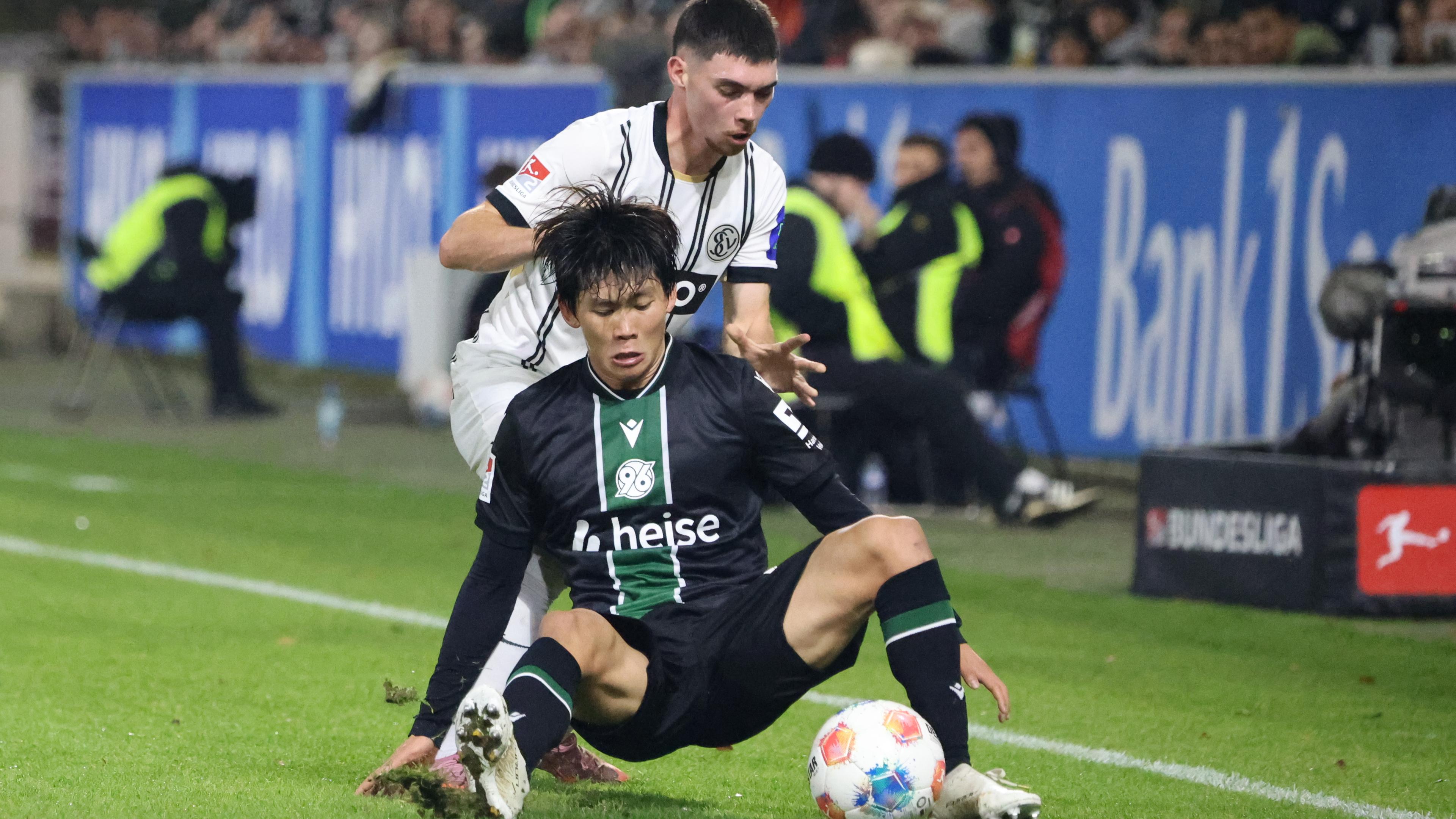 Hayate Matsuda (Hannover) fällt im Zweikampf mit Felix Keidel auf den Boden