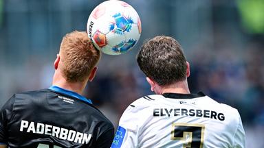 Zwei Fußballspieler, einer im Trikot des SV Elversberg und einer im SC Paderborn 07 Trikot köpfen einen Fußball.