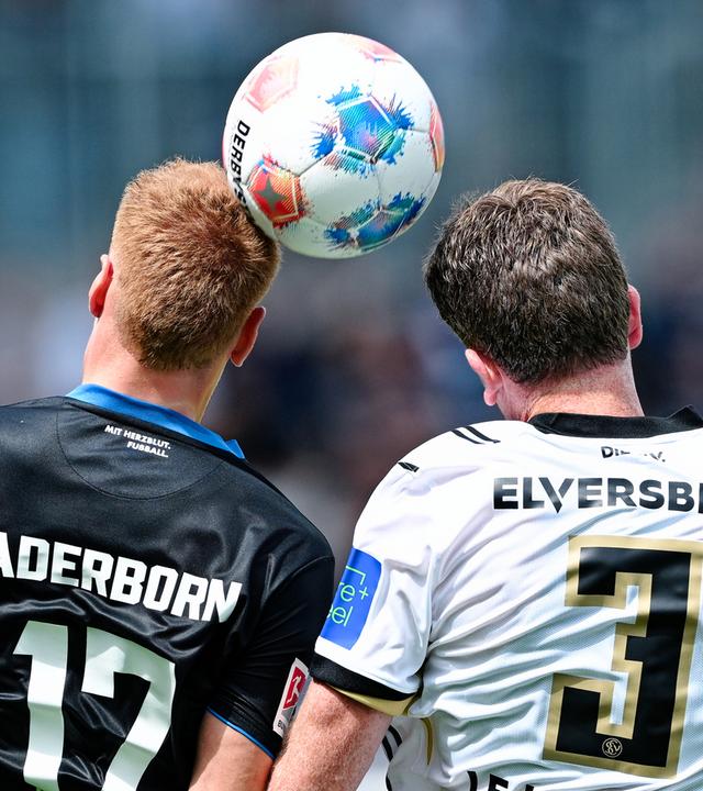 Zwei Fußballspieler, einer im Trikot des SV Elversberg und einer im SC Paderborn 07 Trikot köpfen einen Fußball.