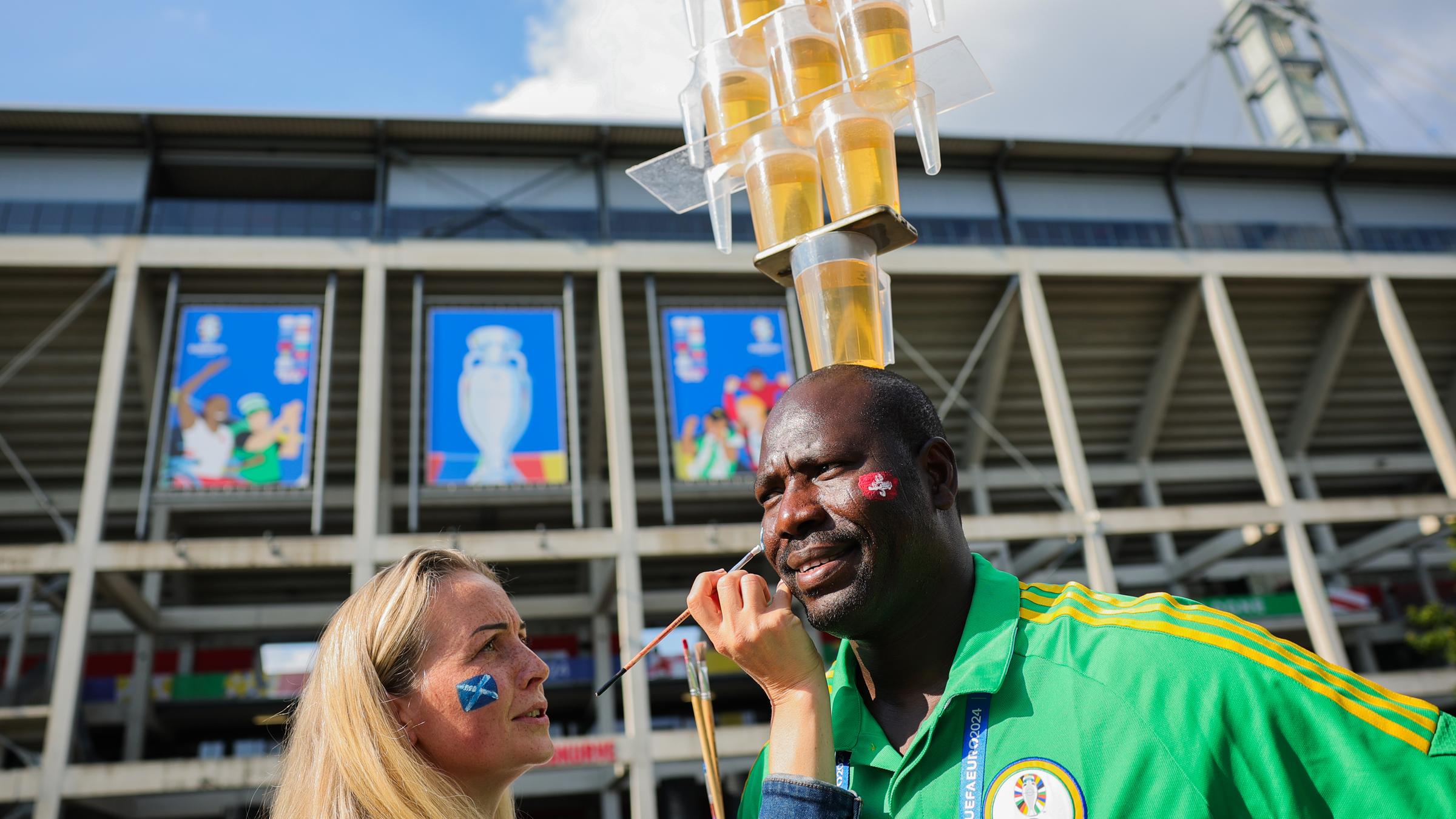 Lena aus der Ukraine malt Mohammed eine schottische Fahne auf die Wange.