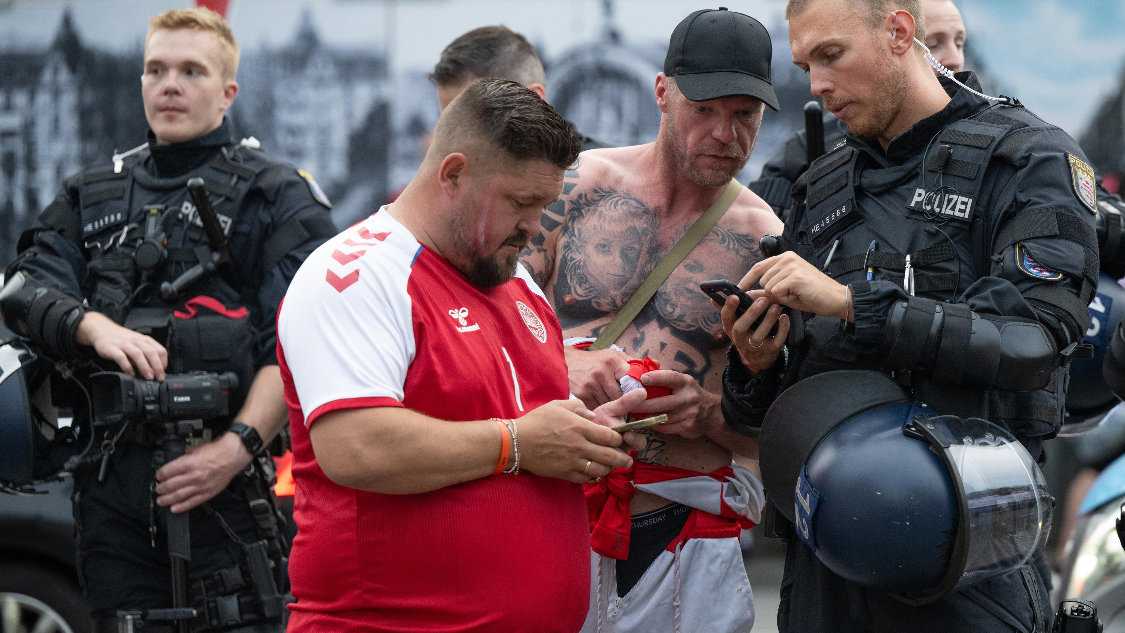 Polizisten erklären zwei Fans den Weg in die Innenstadt.