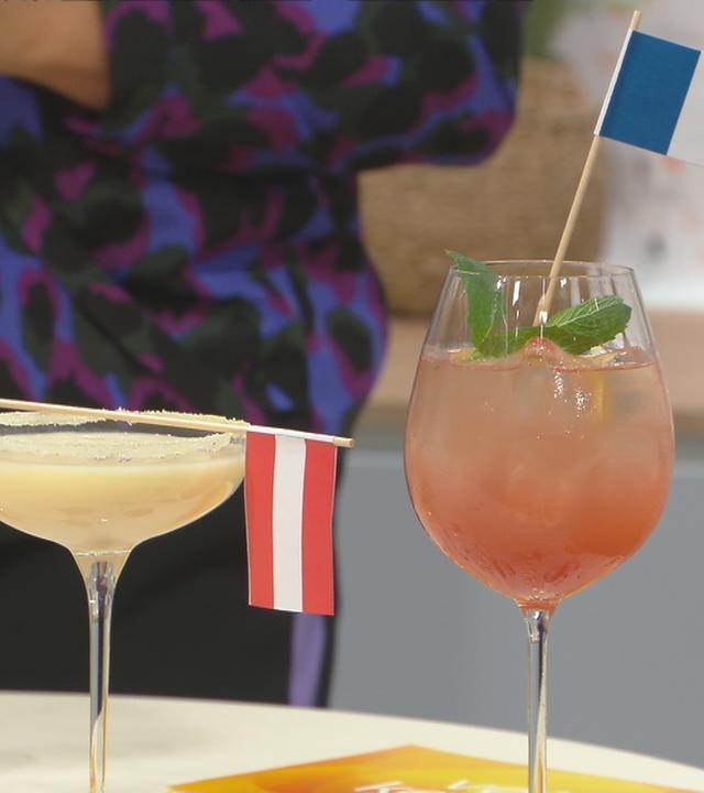 Zwei Cocktails mit Fahnen von Österreich und Frankreich.