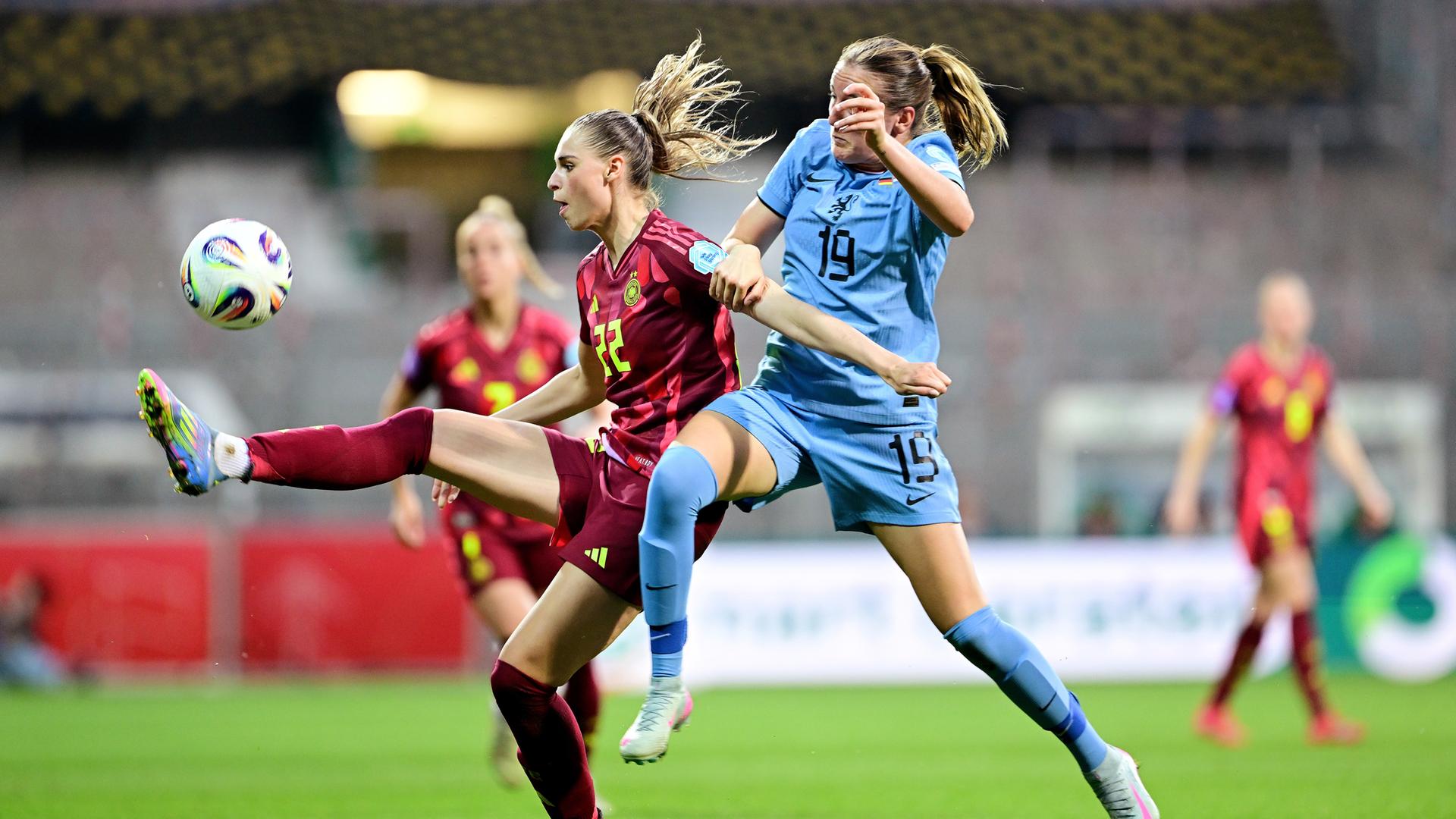 Jule Brand spielt den Ball hoch, daneben ist eine Gegnerin