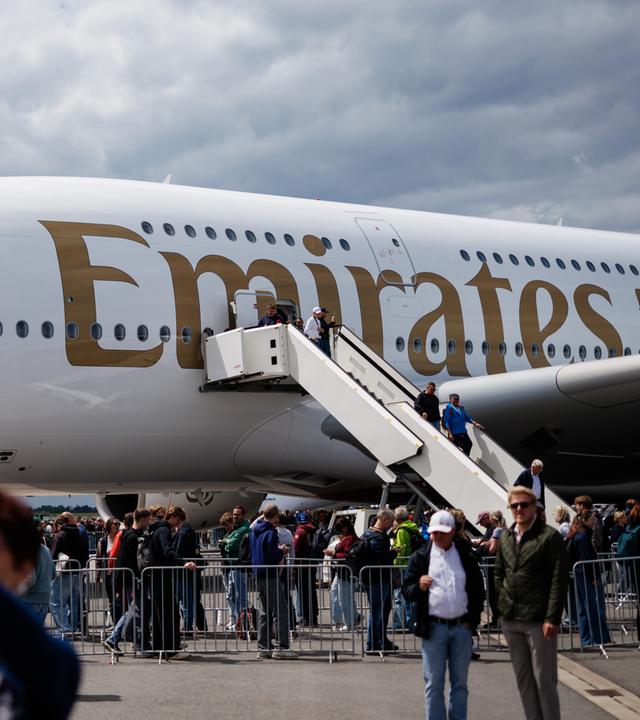 Besucher machen Selfies vor einem Airbus A380-800 der Fluggesellschaft Emirates