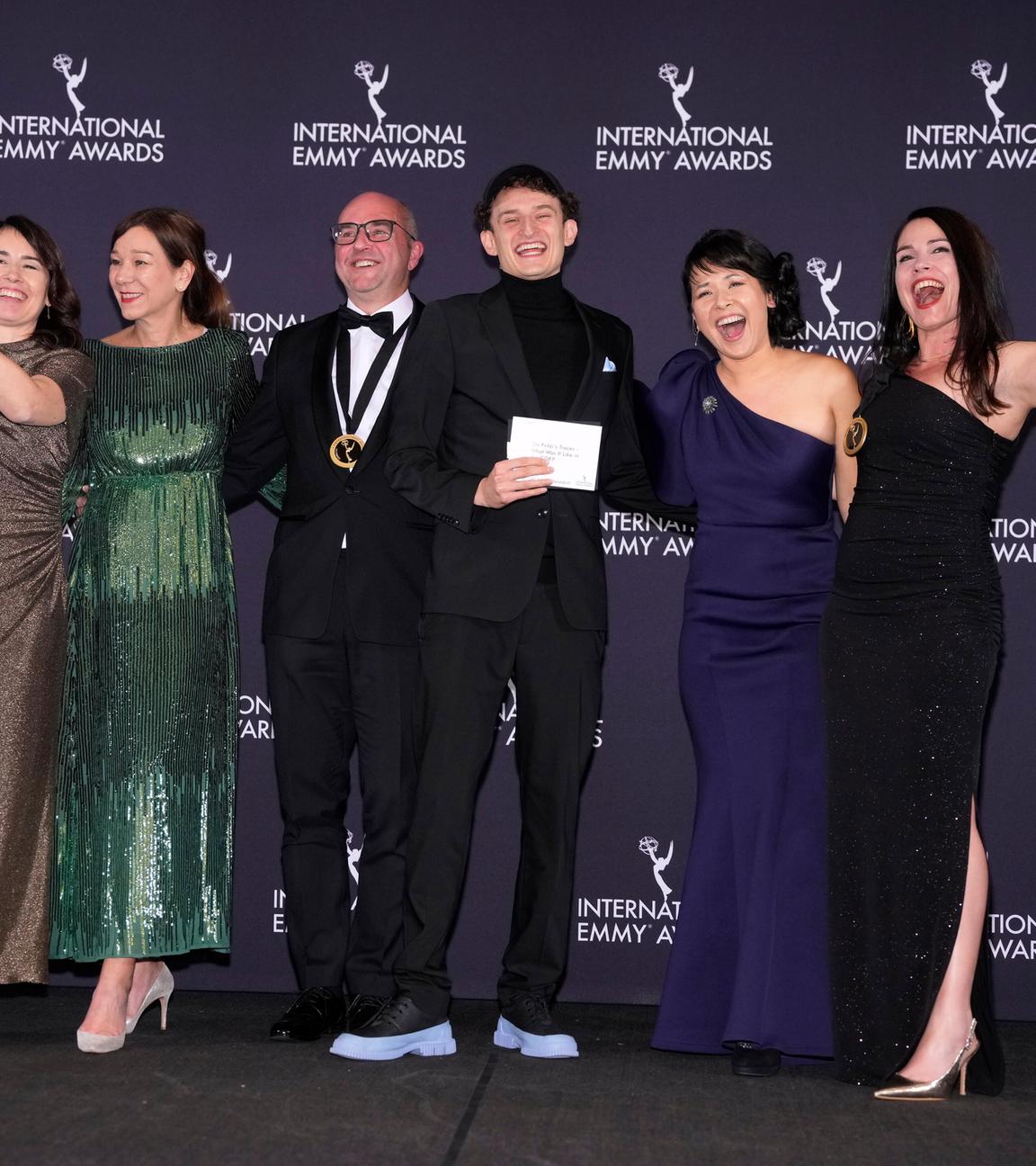 24.11.2025, USA, New York: Anke Lindemann (l), Ralf Kukula (3.v.l), Gewinner in der Kategorie «Kids: Factual & Entertainment» für «Auf Fritzis Spuren - Wie war das so in der DDR?», erscheinen im Presseraum während der 53. International Emmy Awards im New York Hilton Midtown.