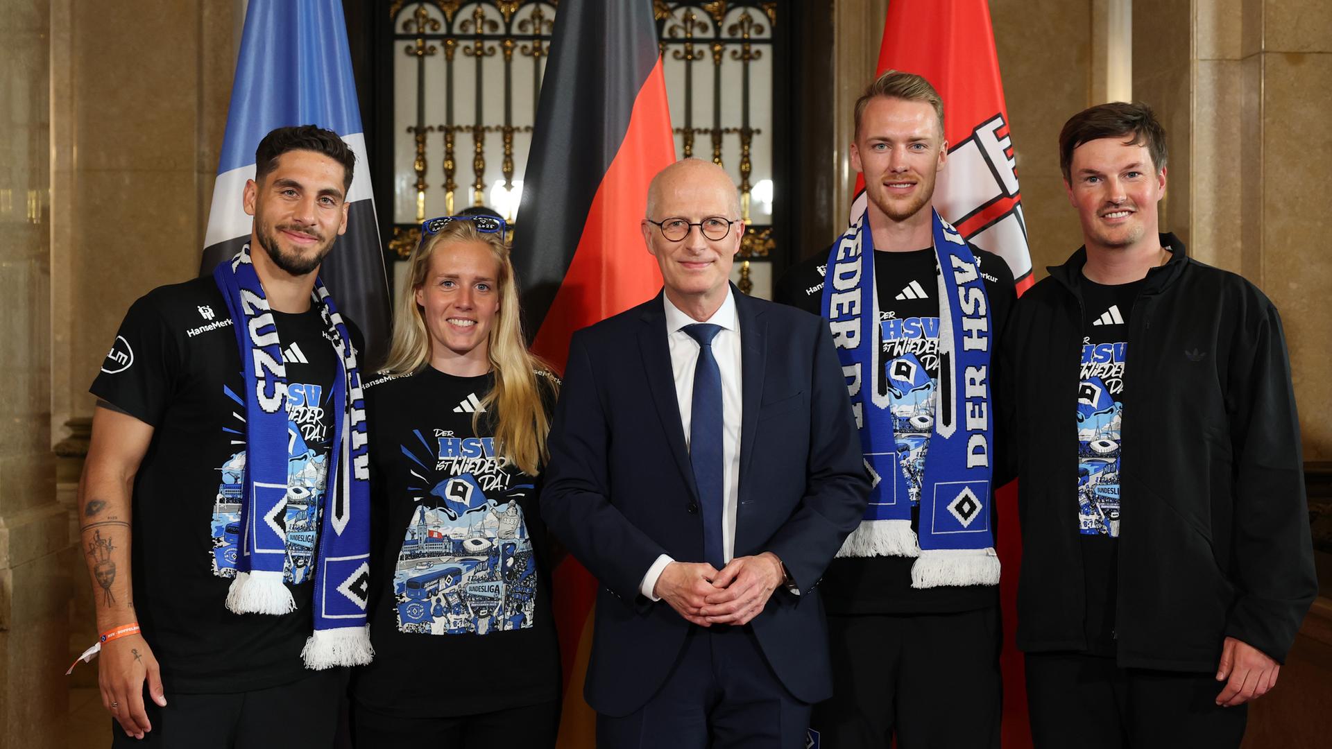 Peter Tschentscher (M, SPD), Erster Bürgermeister und Präsident des Senats der Freien und Hansestadt Hamburg, steht mit Hamburgs Ludovit Reis (l-r), Sarah Stöckmann, Sebastian Schonlau und Trainer Merlin Polzin auf dem Spiegel im Rathaus.