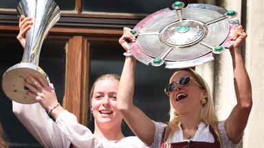 Bayern, München: Alara Sehitler (l) mit dem DFB-Pokal und Giulia Gwinn vom FC Bayern mit der Meisterschale feiern auf dem Rathausbalkon die Deutsche Meisterschaft und den DFB-Pokalsieg.