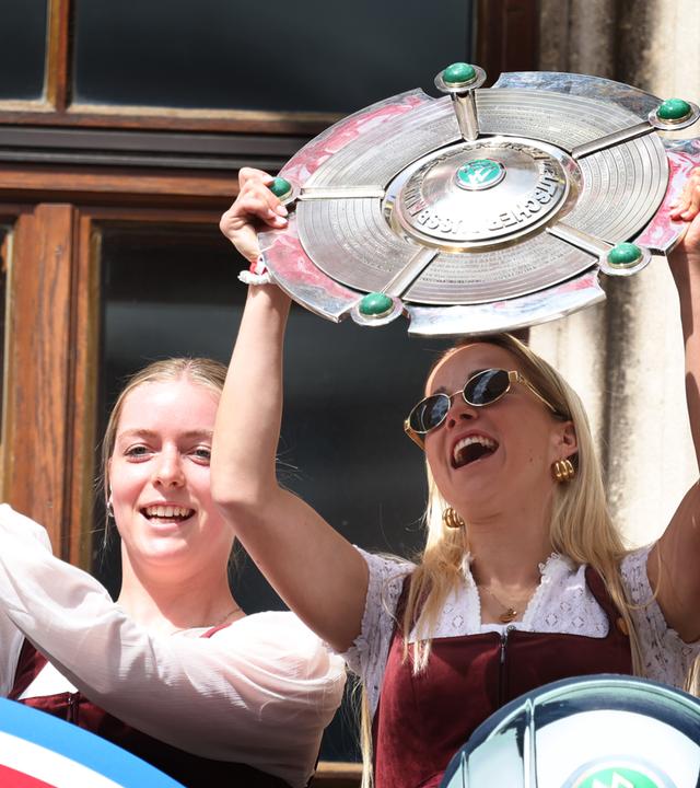Bayern, München: Alara Sehitler (l) mit dem DFB-Pokal und Giulia Gwinn vom FC Bayern mit der Meisterschale feiern auf dem Rathausbalkon die Deutsche Meisterschaft und den DFB-Pokalsieg.