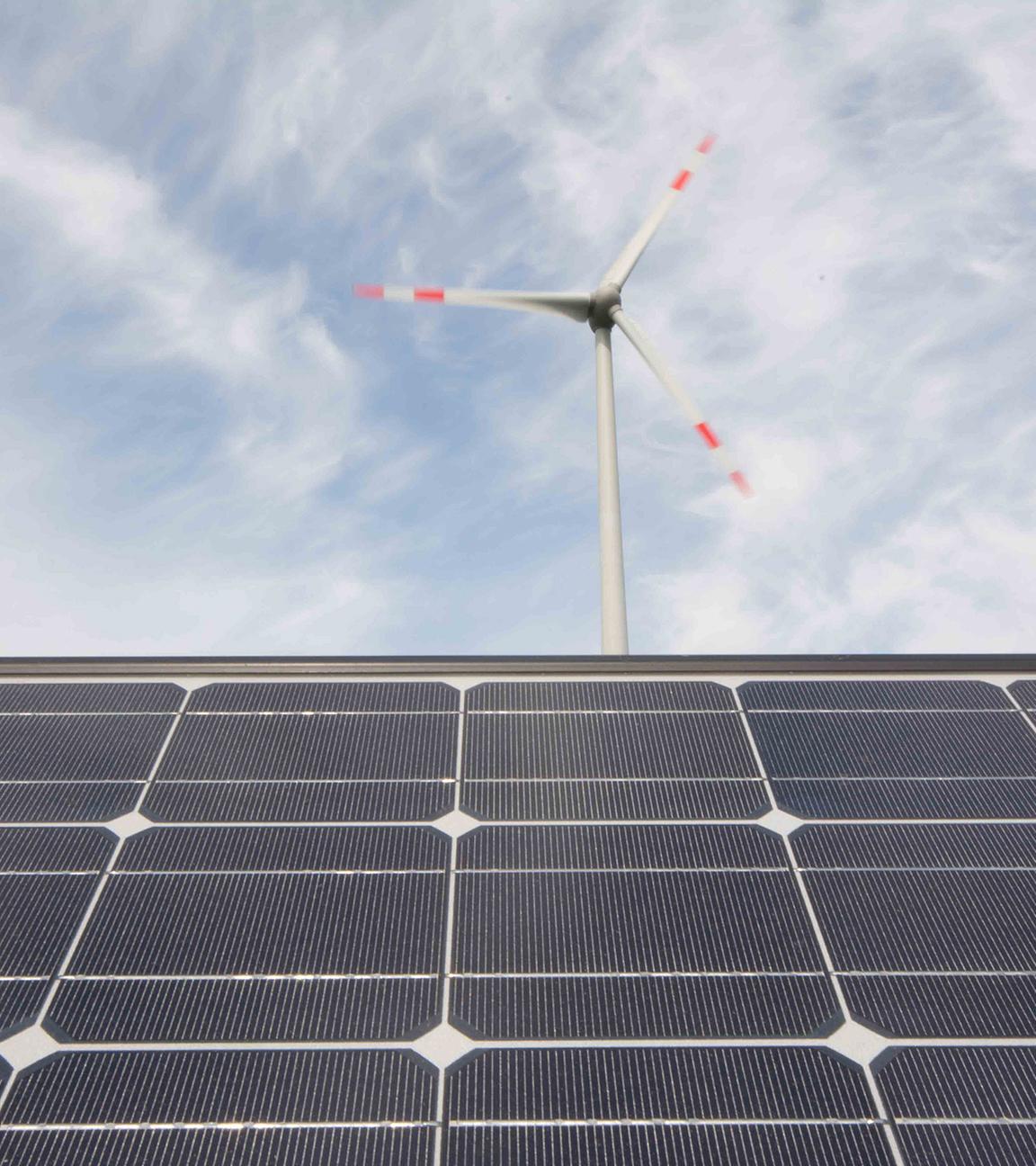 Technologien für eine erfolgreiche Energiewende, Solarmodule und eine Windkraftanlage.