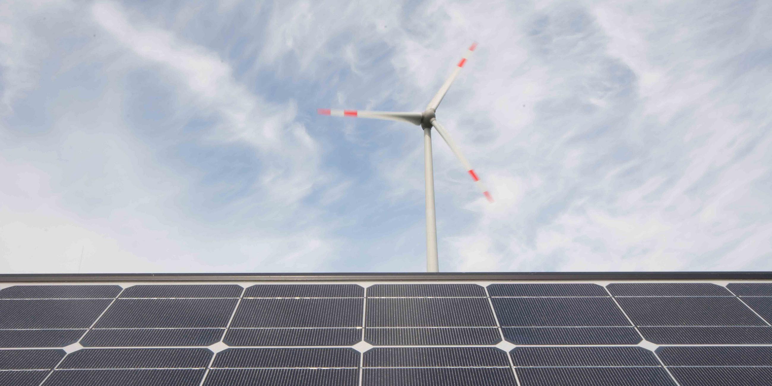 Technologien für eine erfolgreiche Energiewende, Solarmodule und eine Windkraftanlage.