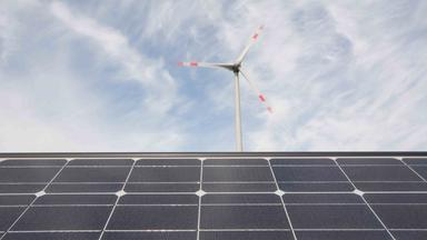 Technologien für eine erfolgreiche Energiewende, Solarmodule und eine Windkraftanlage.