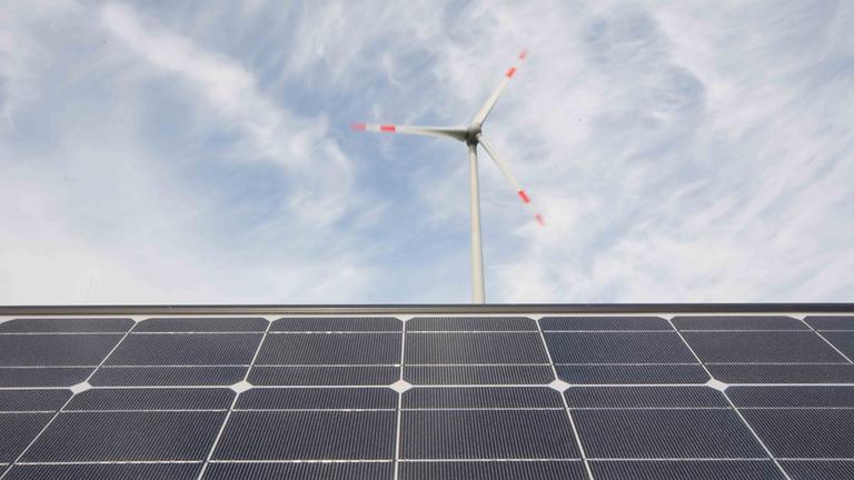 Technologien für eine erfolgreiche Energiewende, Solarmodule und eine Windkraftanlage.