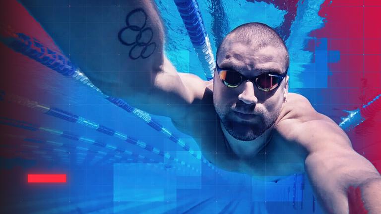 Unterwasseraufnahme des Schwimmers Marius Kusch im Becken während des Trainings. Der ehemalige Olympia-Sportler trägt eine Schwimmbrille und streckt den Arm nach vorn in Richtung Kamera. Auf dem Oberarm ist ein Tattoo mit olympischen Ringen zu sehen. Im Hintergrund verlaufen die Leinenbahnen des Pools, das Bild ist in kräftigen Blau- und Magentatönen gestaltet, zudem ist ein grafisches Raster-Overlay sichtbar.
