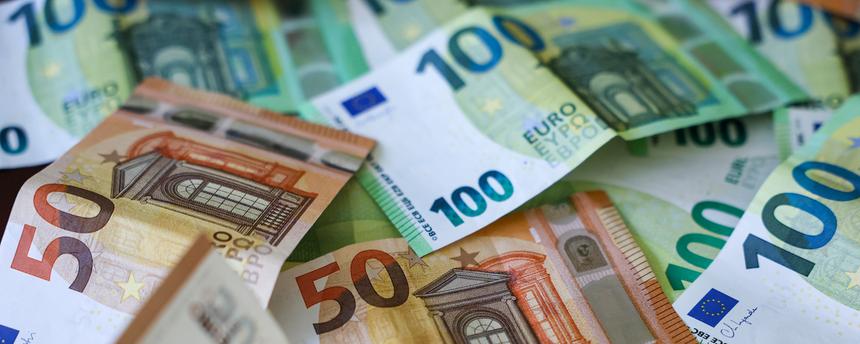 Mehrere Hunderter und Fünfziger Euro Geldscheine liegen auf einem Tisch.