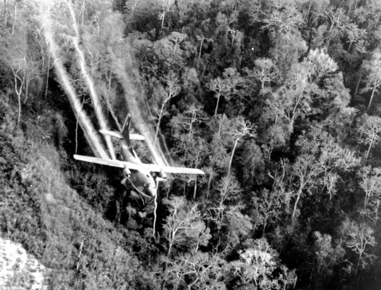 Auf einem vom US-Verteidigungsministerium veröffentlichten Foto vom Mai 1966 fliegt eine C-123 der US-Luftwaffe tief über eine südvietnamesische Autobahn und versprüht Entlaubungsmittel auf den dichten Dschungelbewuchs neben der Straße, um während des Vietnamkrieges Verstecke der Vietcong zu zerstören.